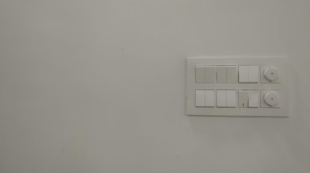  A white switchboard with several switches. 
